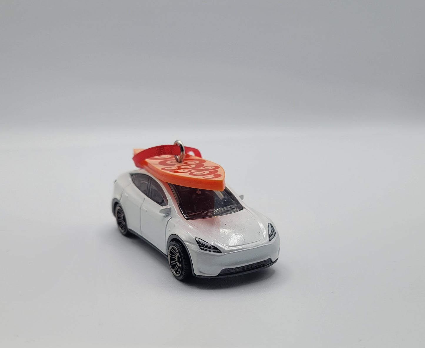Tesla Model Y White Diecast Christmas Ornament with Surfboard on Roof – Color of Surfboard May Vary – Perfect Holiday Decoration for Car Enthusiasts